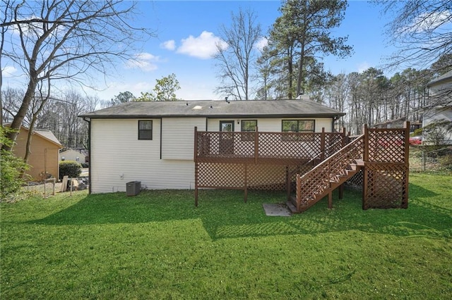 rear view of house with a yard, a deck, stairs, and fence