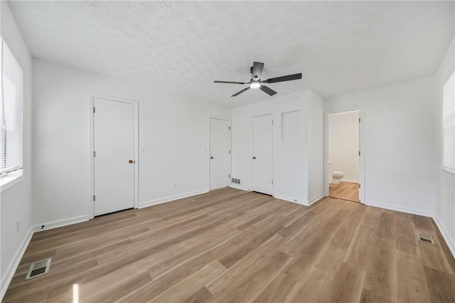 unfurnished bedroom featuring light wood finished floors, baseboards, and visible vents