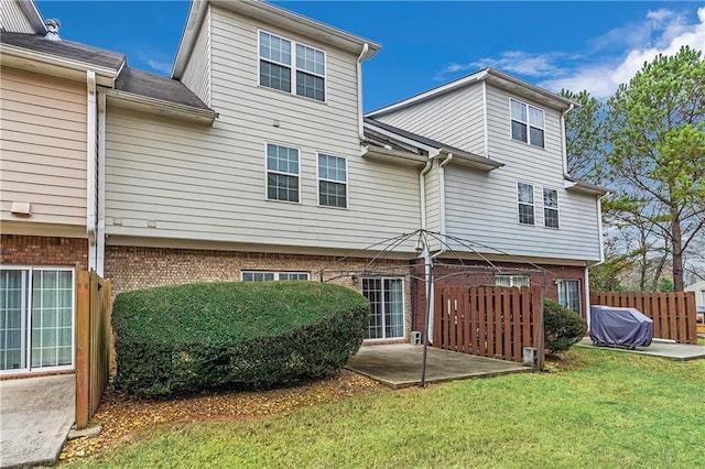 back of property featuring a lawn and a patio