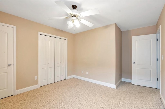 unfurnished bedroom with ceiling fan, light carpet, and a closet