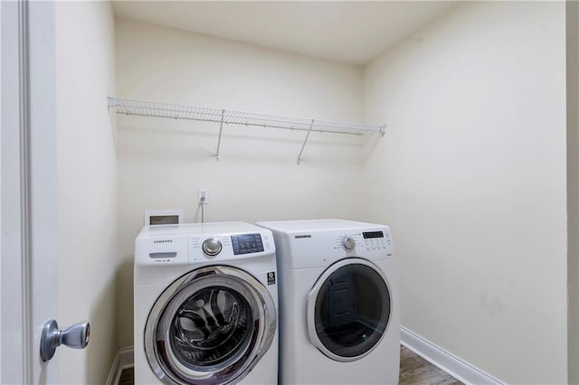 laundry room with separate washer and dryer and hardwood / wood-style floors