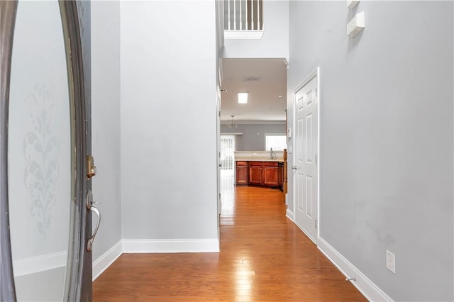 corridor featuring light wood-type flooring and sink