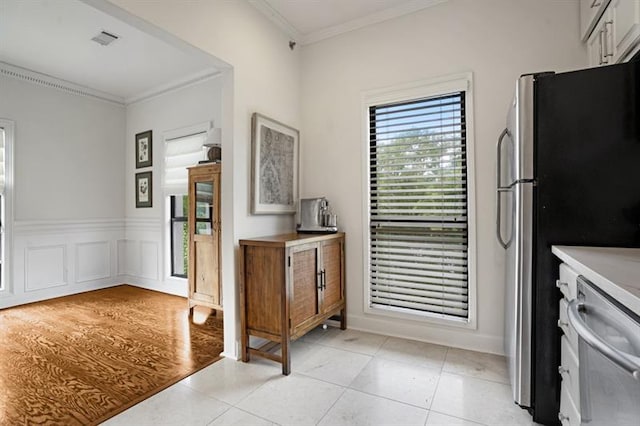 kitchen featuring crown molding, light hardwood / wood-style floors, and appliances with stainless steel finishes