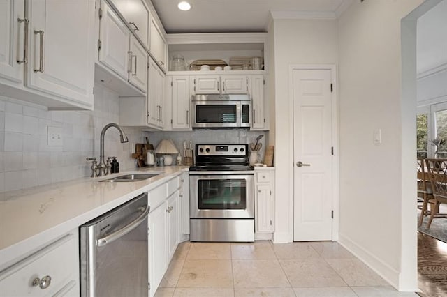 kitchen with appliances with stainless steel finishes, white cabinetry, crown molding, and sink