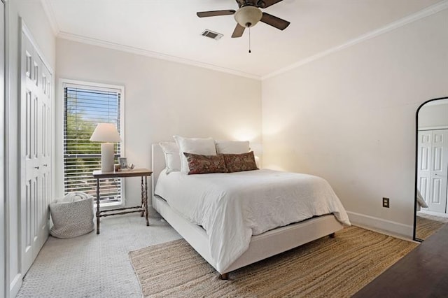 bedroom with ceiling fan, crown molding, and a closet