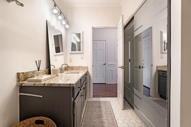 bathroom with hardwood / wood-style floors, vanity, and ornamental molding