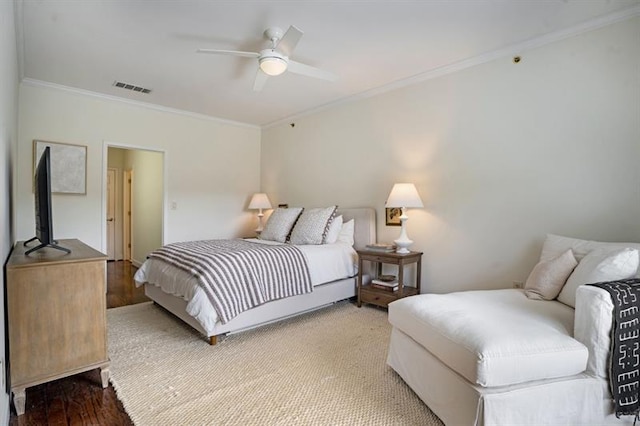 bedroom with hardwood / wood-style flooring, ceiling fan, and ornamental molding