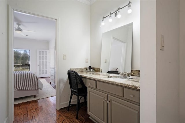 bathroom featuring hardwood / wood-style floors, vanity, ceiling fan, and crown molding