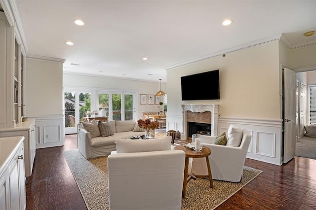 living room featuring a premium fireplace, crown molding, and dark wood-type flooring