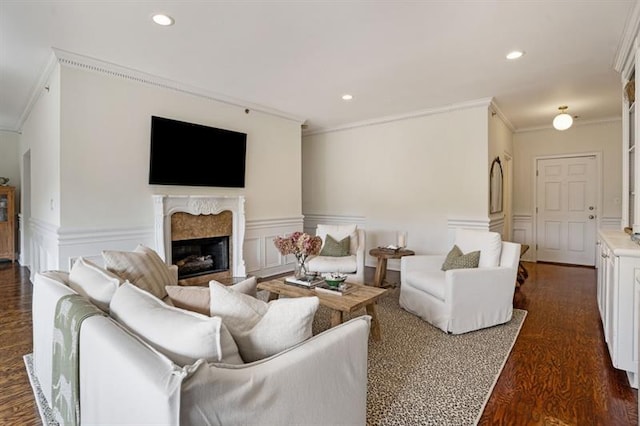 living room featuring dark wood-type flooring, ornamental molding, and a premium fireplace