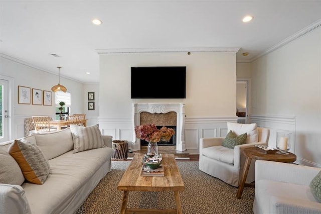 living room featuring hardwood / wood-style floors, a high end fireplace, and ornamental molding