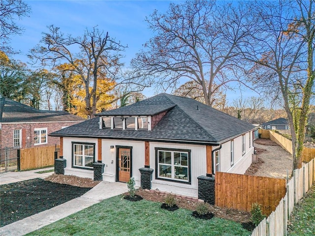 view of front of property with roof with shingles, a front lawn, a fenced front yard, and central air condition unit