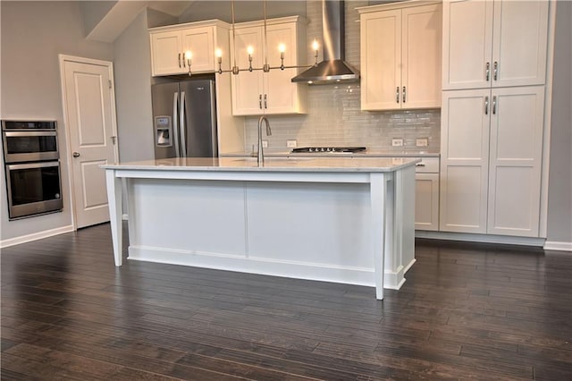 6603 Sterling Dr, Atlanta, GA 30328 - kitchen featuring wall chimney range hood, appliances with stainless steel finishes, backsplash, a center island with sink, and dark wood-style flooring