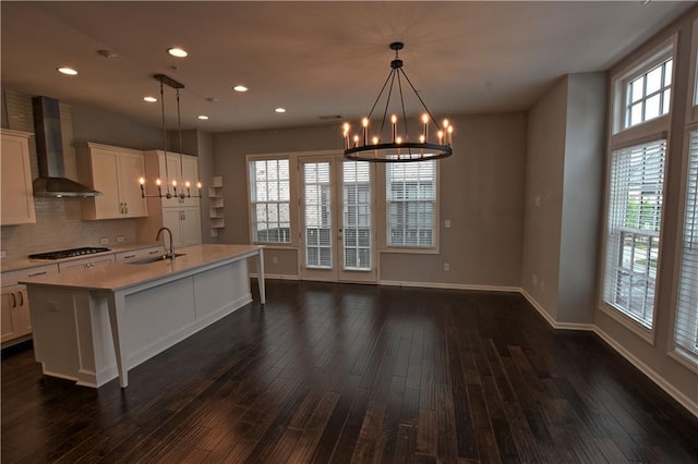6603 Sterling Dr, Atlanta, GA 30328 - kitchen featuring a chandelier, wall chimney range hood, gas cooktop, a sink, and light countertops