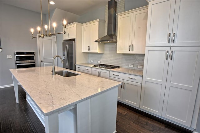 6603 Sterling Dr, Atlanta, GA 30328 - kitchen featuring wall chimney range hood, stainless steel appliances, a sink, dark wood finished floors, and a kitchen island with sink