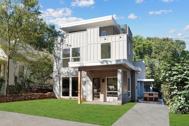 back of house featuring a jacuzzi and a lawn