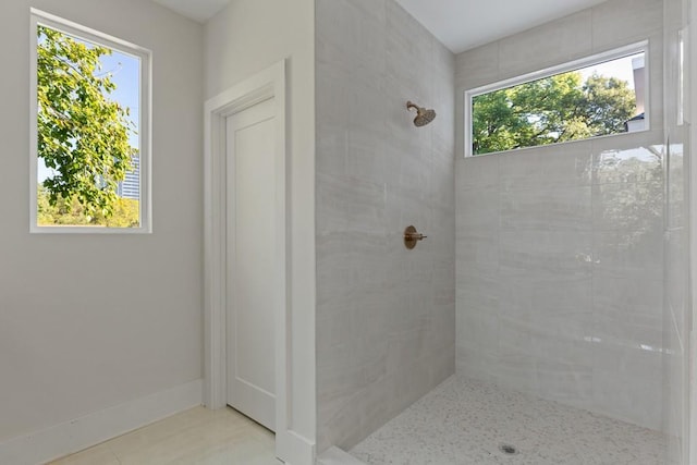 bathroom with tiled shower and tile patterned floors