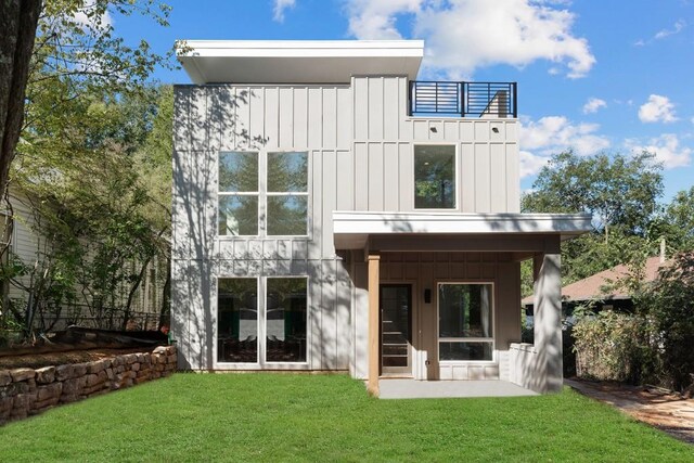 back of house with a patio area and a lawn