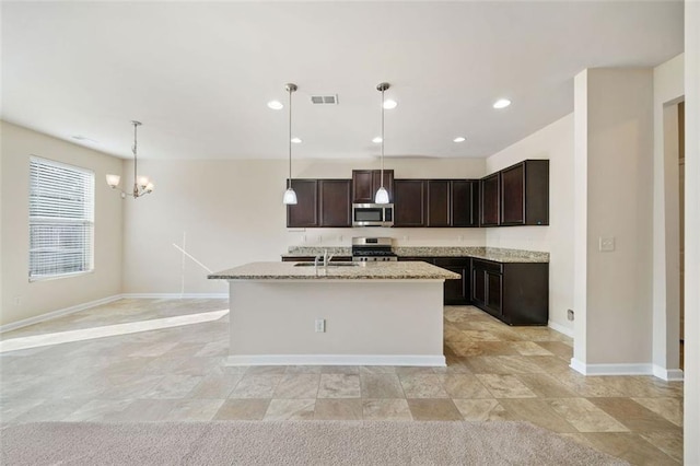 kitchen with a center island with sink, pendant lighting, dark brown cabinets, and stainless steel appliances