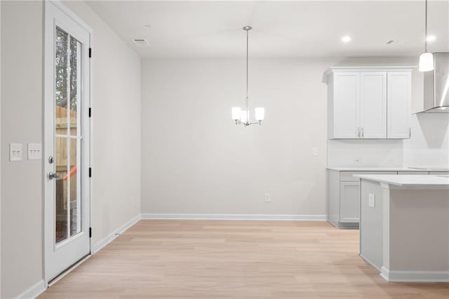 kitchen with white cabinetry, light hardwood / wood-style flooring, and pendant lighting