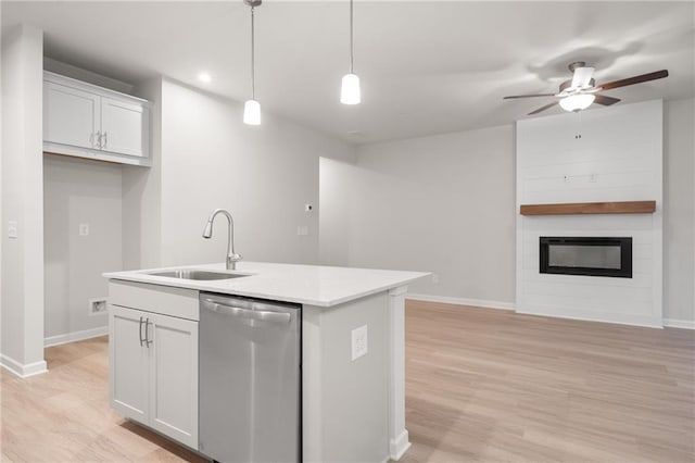 kitchen featuring dishwasher, a kitchen island with sink, white cabinets, and decorative light fixtures