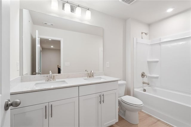 full bathroom featuring vanity, hardwood / wood-style flooring, bathing tub / shower combination, and toilet