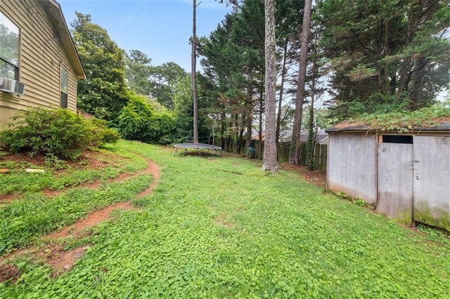 5016 Comanche Ct NW, Lilburn, GA 30047 - view of grassy yard featuring a trampoline, a storage shed, and cooling unit