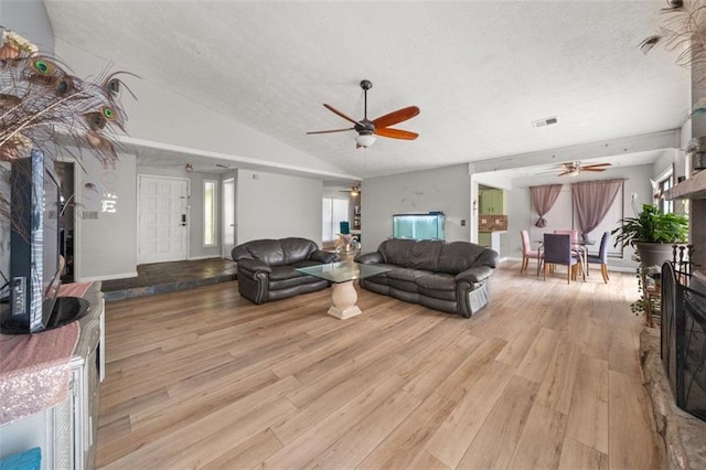 5016 Comanche Ct NW, Lilburn, GA 30047 - living area with a ceiling fan, a fireplace, a textured ceiling, wood finished floors, and vaulted ceiling