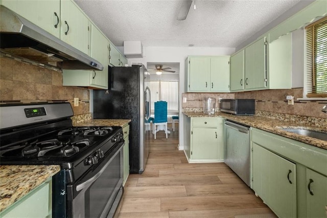 5016 Comanche Ct NW, Lilburn, GA 30047 - kitchen with stainless steel appliances, ceiling fan, under cabinet range hood, light wood-style floors, and a textured ceiling