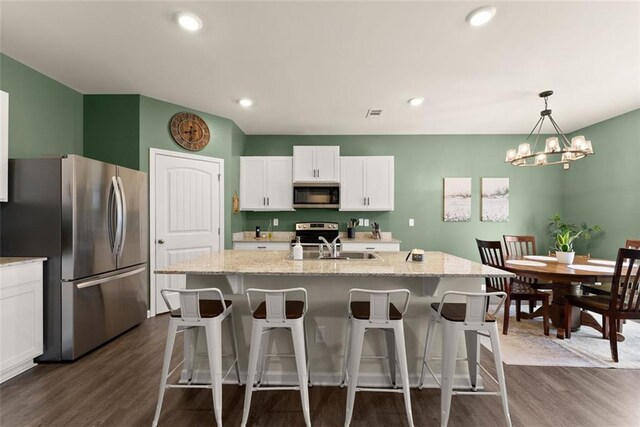 867 Starbuck Pkwy, Pendergrass, GA 30567 - kitchen featuring a sink, dark wood-style flooring, appliances with stainless steel finishes, and a kitchen bar