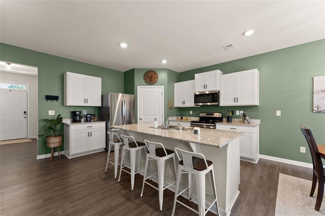867 Starbuck Pkwy, Pendergrass, GA 30567 - kitchen with appliances with stainless steel finishes, white cabinets, a kitchen breakfast bar, and dark wood-type flooring