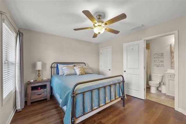 bedroom featuring dark wood-type flooring, ceiling fan, and ensuite bath