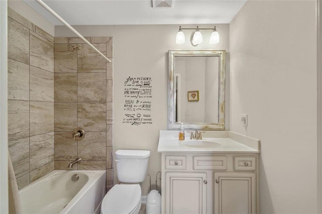 full bathroom with tiled shower / bath combo, vanity, and toilet