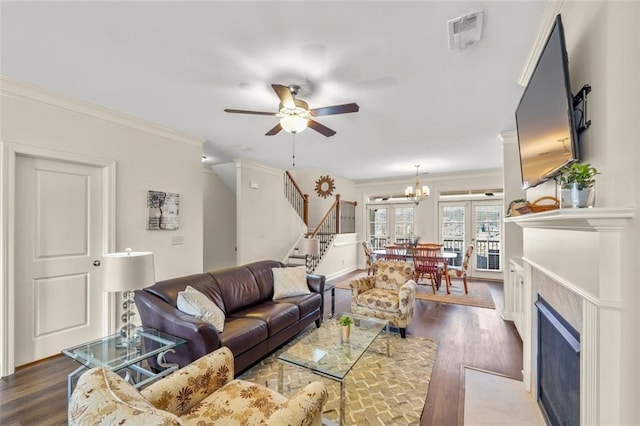 living room featuring crown molding, dark wood-type flooring, ceiling fan with notable chandelier, and french doors