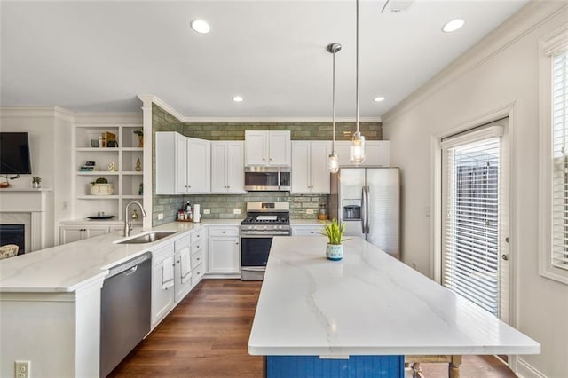 kitchen with stainless steel appliances, a center island, sink, and hanging light fixtures