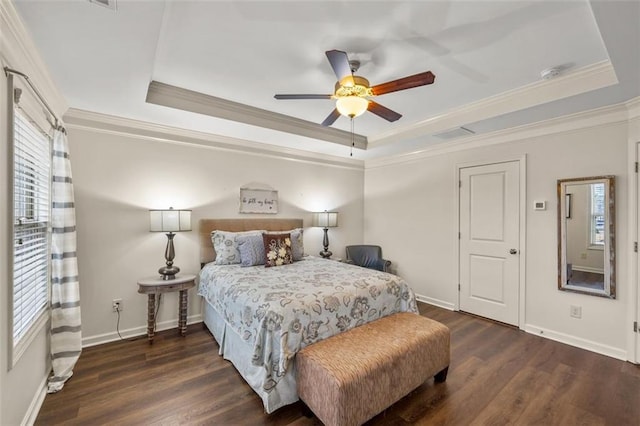 bedroom featuring crown molding, a tray ceiling, dark hardwood / wood-style floors, and ceiling fan