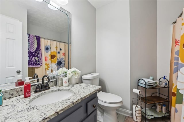 bathroom with curtained shower, toilet, and vanity