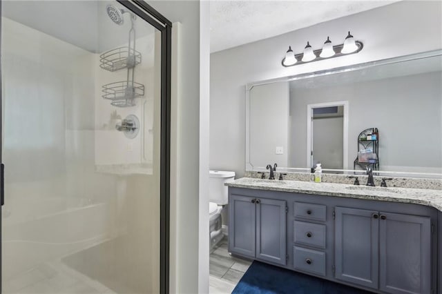 bathroom featuring a sink, toilet, and a stall shower