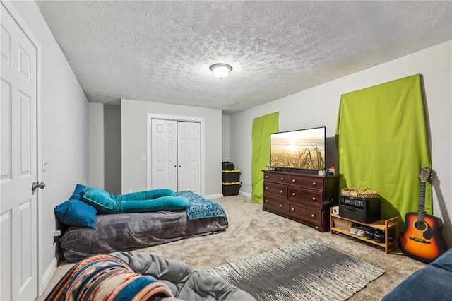 bedroom with baseboards, a closet, carpet floors, and a textured ceiling