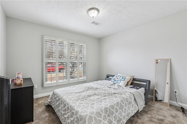 carpeted bedroom featuring baseboards, visible vents, and a textured ceiling