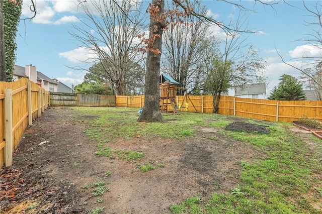 view of yard with a playground and a fenced backyard