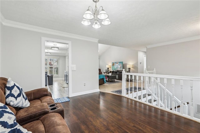 living room featuring crown molding, baseboards, an inviting chandelier, wood finished floors, and a textured ceiling