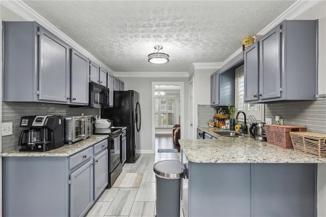 kitchen featuring gray cabinetry, crown molding, a peninsula, black appliances, and a sink