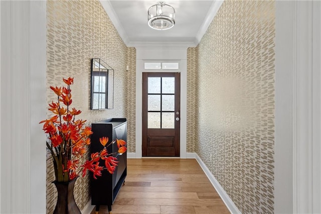 entryway with ornamental molding and wood-type flooring