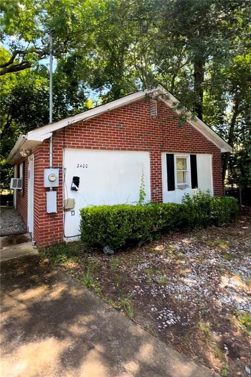 view of property exterior featuring a garage, an outbuilding, and cooling unit