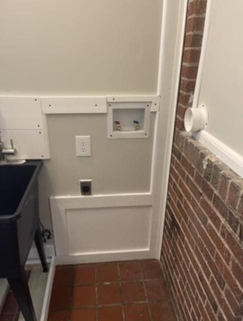 laundry area featuring brick wall, washer hookup, and hookup for an electric dryer