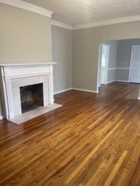 unfurnished living room featuring ornamental molding and dark hardwood / wood-style floors