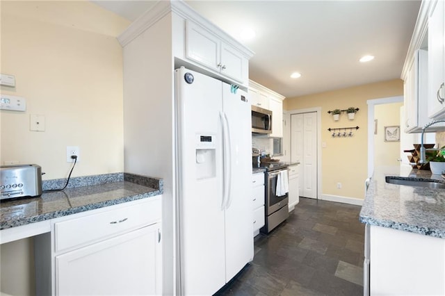 kitchen featuring dark stone countertops, white cabinetry, sink, and appliances with stainless steel finishes