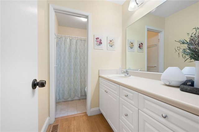 bathroom with a shower with curtain, vanity, and hardwood / wood-style flooring