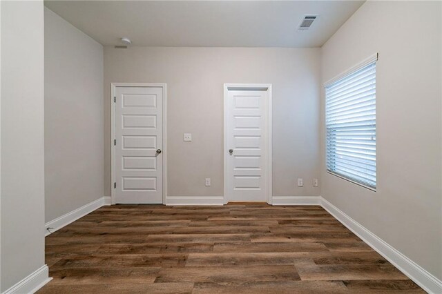 unfurnished bedroom with dark hardwood / wood-style flooring